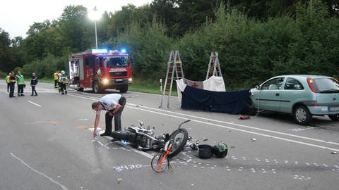Ein Polizist sprüht Markierungen für die Aufnahme des Unfallhergangs rund um ein Motorrad, das nach einem Unfall auf der Straße liegt. (Foto: dpa Bildfunk, picture alliance/dpa/TNN, David Pichler)