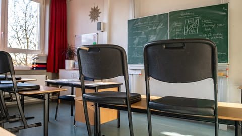 Auf Schreibtischen aufgestellte Stühle in einem Klassenzimmer einer Schule (Symbolfoto) (Foto: dpa Bildfunk, picture alliance/dpa/Guido Kirchner (Symbolfoto))