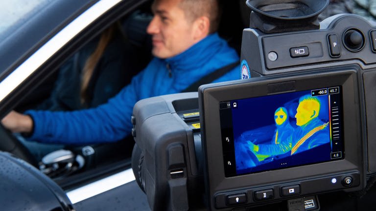 Mann mit Anschnallgurt in einem Auto, Monitor zeigt Wärmebild (Foto: Pressestelle, ZF Friedrichshafen)