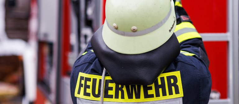 Ein Feuerwehrmann mit Helm von hinten. (Foto: dpa Bildfunk, picture alliance/dpa/Philipp von Ditfurth)