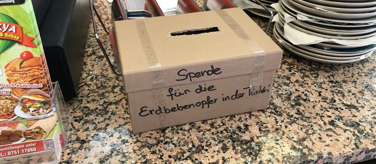 Spendenbox neben einer Kasse im Döner-Imbiss (Foto: SWR, Moritz Kluthe)