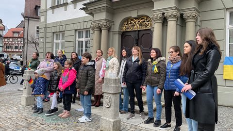 Frauen und Mädchen stehen vor dem Rathaus und singen. (Foto: SWR)