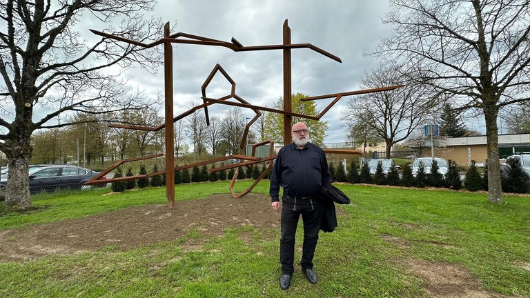 Der Künstler Robert Schad steht vor seiner Skulptur "der Schrei", einem abstrakten Kunstwerk aus rostbraunem Stahl (Foto: SWR, Alfred Knödler)