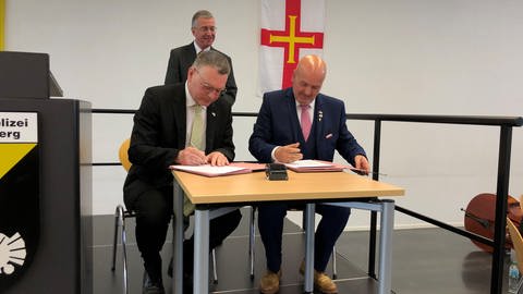 Der Biberacher OB Norbert Zeidler und Jonathan Le Tocq aus Guernsey unterschreiben einen Freundschaftsvertrag. (Foto: SWR, Martin Hattenberger)