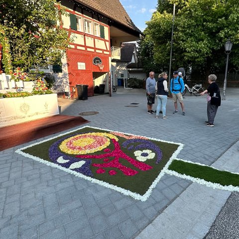 Ein bunter Blumenteppich liegt auf der Straße und führt zu einem Altar. (Foto: SWR)
