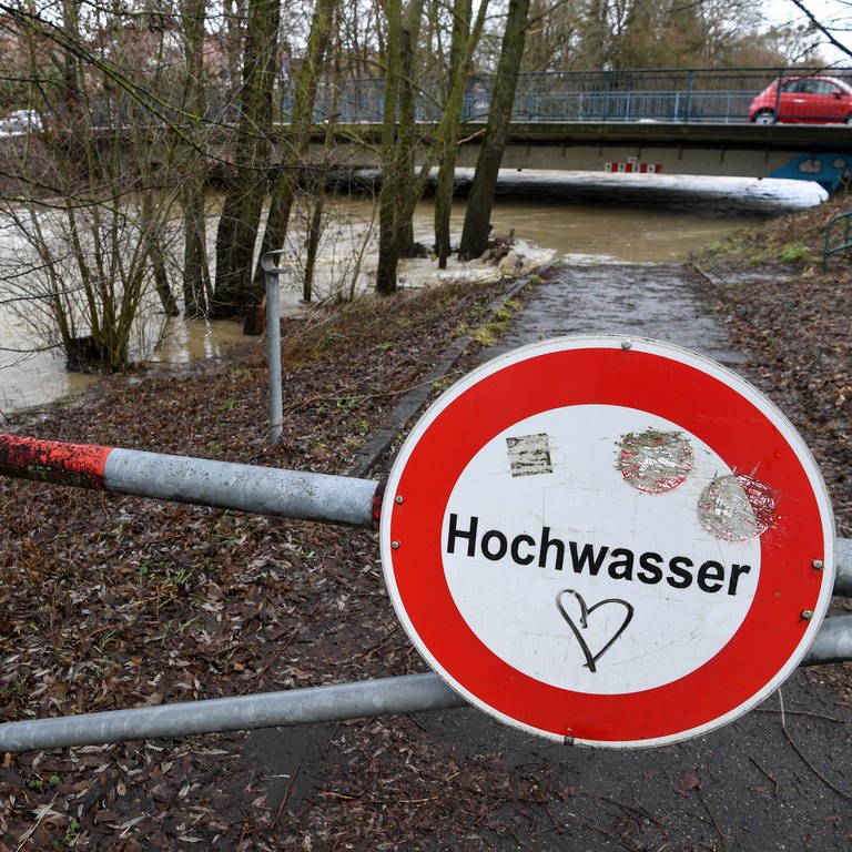Ein Schild mit der Aufschrift Hochwasser steht am Ufer des Flusses Rotach. Die Rotach tritt kurz vor der Mündung in den Bodensee über die Ufer. (Foto: dpa Bildfunk, picture alliance/dpa | Felix Kästle)