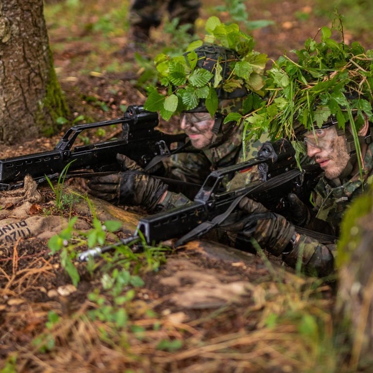 Soldaten der Bundeswehr mit Tarnzweigen auf dem Kopf bei einer Übung im Wald. (Foto: dpa Bildfunk, picture alliance/dpa/Christoph Schmidt (Symbolbild))