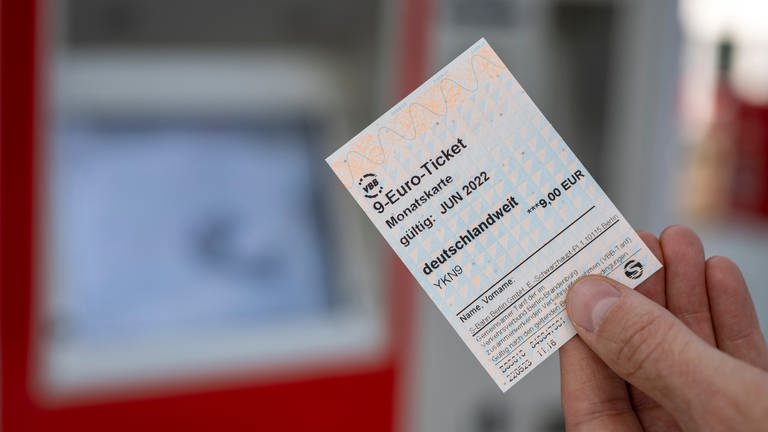 Jemand hält ein 9-Euro-Ticket in der Hand (Foto: dpa Bildfunk, picture alliance/Monika Skolimowska)