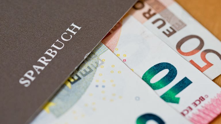 Geldscheine liegen in einem Sparbuch (Foto: picture-alliance / Reportdienste, Picture Alliance)