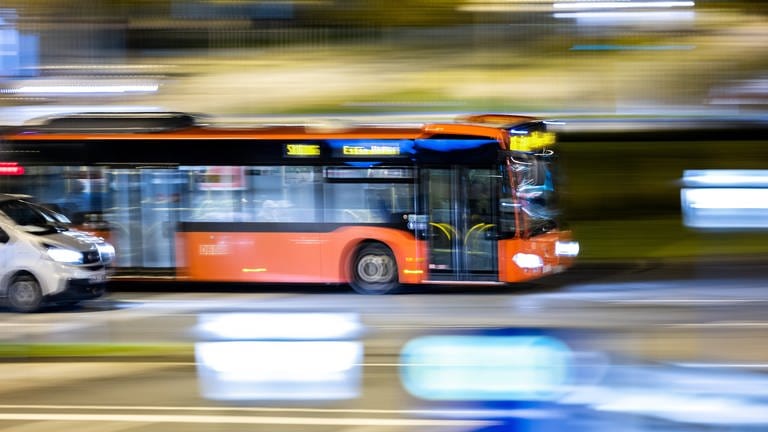 Ein Bus fährt auf einer beleuchteten Straße.  (Foto: dpa Bildfunk, picture alliance/dpa/Marcel Kusch (Symbolbild))