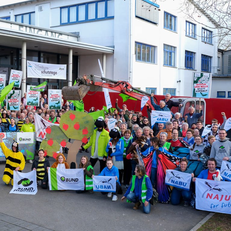 Menschen halten Plakate hoch bei den 46. Naturschutztagen in Radolfzell