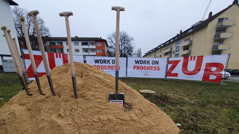 Spaten stecken in Sandhaufen vor Häuserblock in Konstanz (Foto: SWR, Friederike Fiehler)