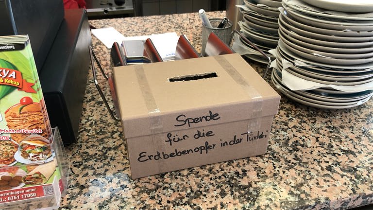 Spendenbox neben einer Kasse im Döner-Imbiss (Foto: SWR, Moritz Kluthe)