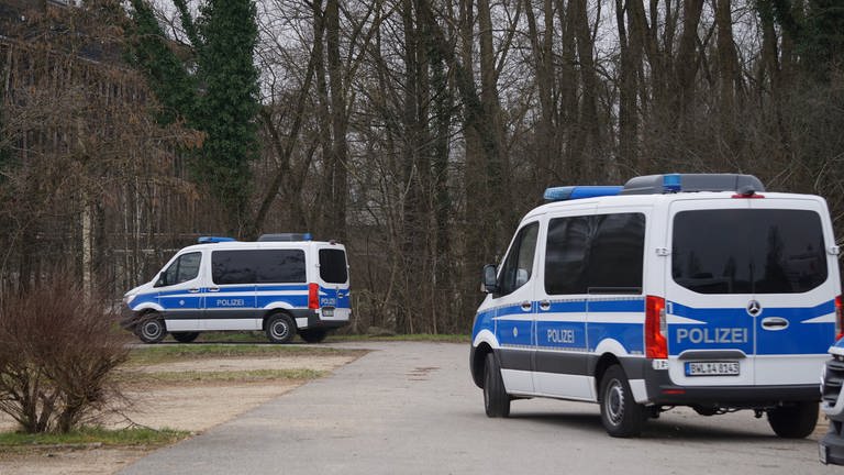 Zwei Streifenwagen verlassen einen Parkplatz in Radolfzell am Bodensee. Polizisten hatten in dem Gebiet in Ufernähe über Stunden nach einer vermissten 21-Jährigen gesucht. (zu dpa «Bekannter nach Verschwinden einer 21-Jährigen in U-Haft»)