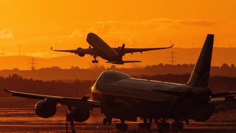 Flugzeug startet in rötlichen Abendhimmel (Foto: picture-alliance / Reportdienste, Boris Roessler)