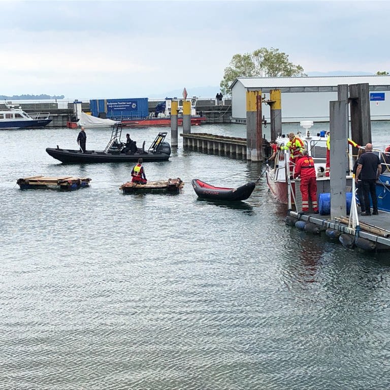 Rettungskräfte sichern Floße und Kanu im Hafen von Friedrichshafen