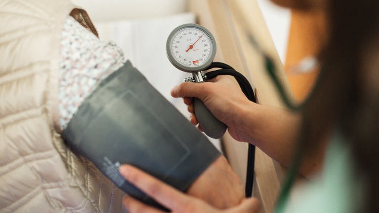 Eine Arzt misst den Blutdruck