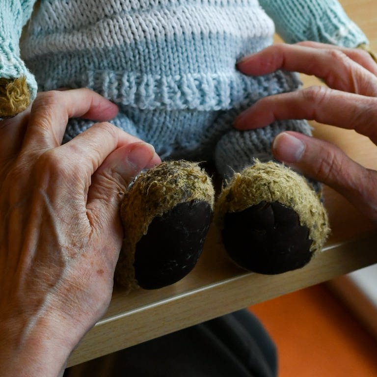 Eine alte Frau hält einen Teddybär
