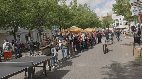 Eine lange Schlange steht in der Laupheimer Mittelstraße an einer Tischtennisplatte an.