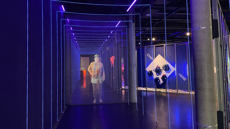 Eine sprechende Projektion lädt die Besucherinnen und Besucher in die Ausstellung ein.