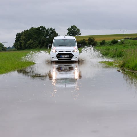 Auto fährt auf überfluteten Weg bei Riedlingen