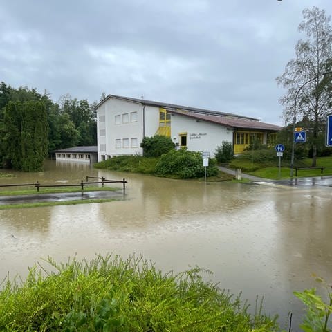 Ein Schulgebäude in Meckenbeuren-Kehlen von außen, das unter Wasser steht.