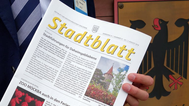 Eine Ausgabe des Amtsblattes der Stadt Crailsheim (Kreis Schwäbisch Hall) wird vor dem Bundesgerichtshof gehalten. (Foto: dpa Bildfunk, picture alliance/dpa | Susanne Kupke)