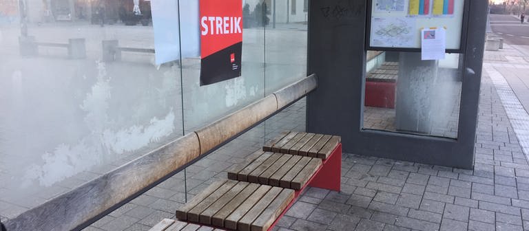 Eine leere Bushaltestelle in Schwäbsich Hall mit einem roten Plakat, auf dem "Streik" steht (Foto: SWR, Archiv)