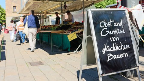 Verkaufsstand mit Schild "Obst und Gemüse von glücklichen Bauern" (Foto: SWR)
