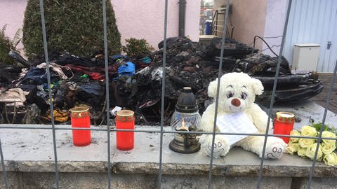 Kerzen und Teddybären stehen am Tag nach dem Brand in Neuenstadt (Foto: SWR)