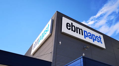 ebm papst Firmenlogo auf Werksgelände an einem Betriebsgebäude. (Foto: SWR)