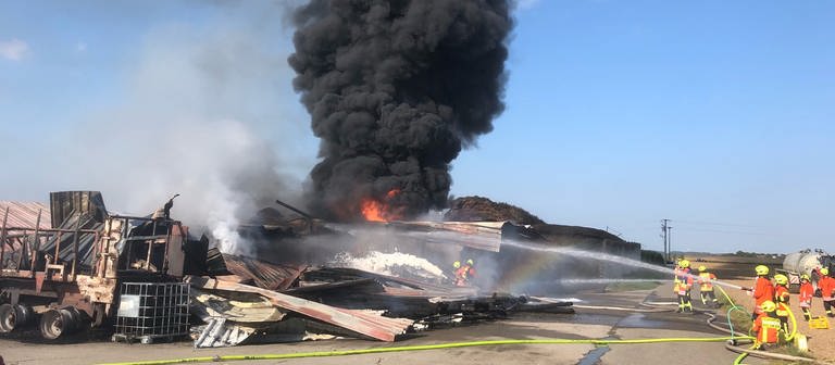 Bild zeigt die abgebrannte Maschinenhalle mit einer großen schwarzen Rauchsäule. (Foto: Klaus Pressler)