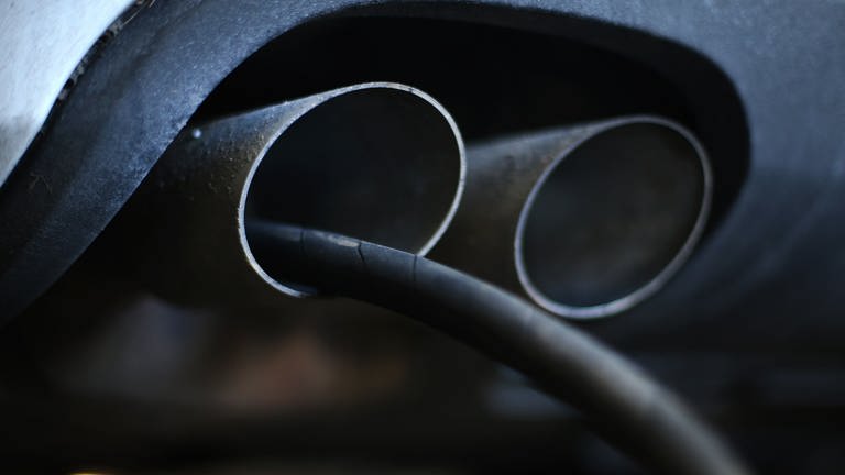 Der Messschlauch eines Geräts zur Abgasuntersuchung für Dieselmotoren steckt im Auspuffrohr eines Audi A4 TDI in einer Werkstatt  (Foto: dpa Bildfunk, Ina Fassbende)