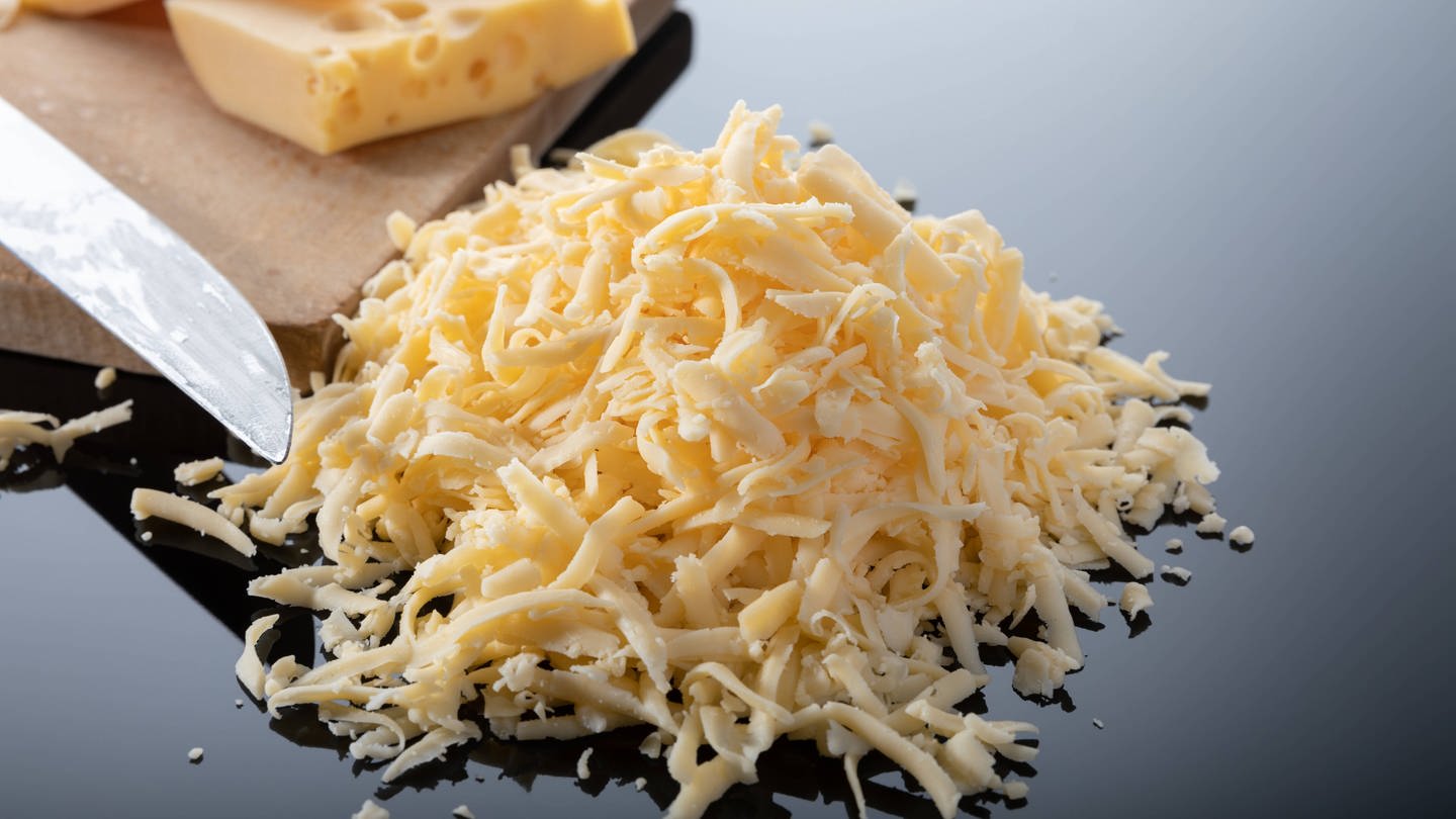 Geriebener Emmentaler Käse auf einem Teller (Foto: IMAGO, Shotshop)