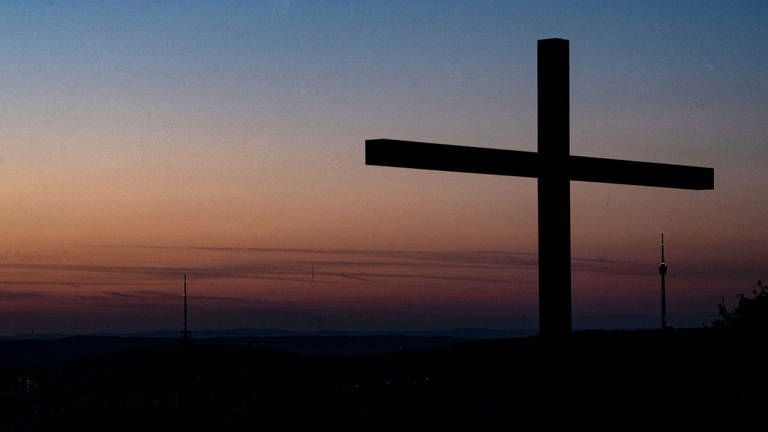 Ein Kreuz vor spätem Sonnenuntergang (Foto: dpa Bildfunk, Picture Alliance)