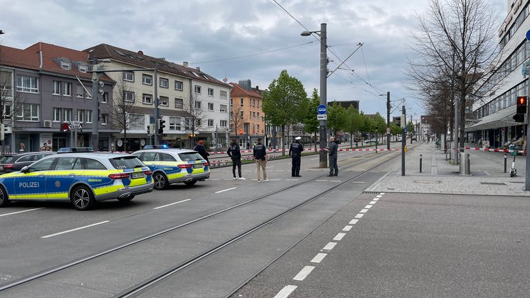 Polizisten bewachen einen mit Polizeiautos und Flatterband abgesperrten Bereich auf der Heilbronner Allee.  (Foto: SWR, Christoph Schöneberger)