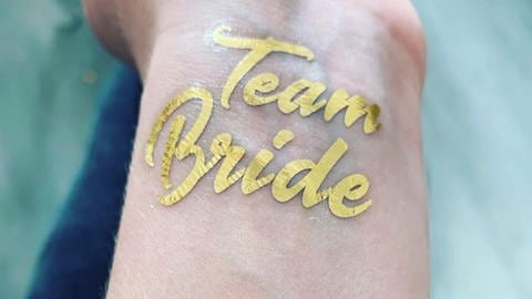 Goldenes Tattoo mit dem Schriftzug Team Bride (Foto: SWR)