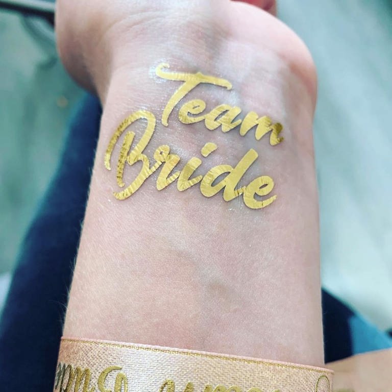 Goldenes Tattoo mit dem Schriftzug Team Bride
