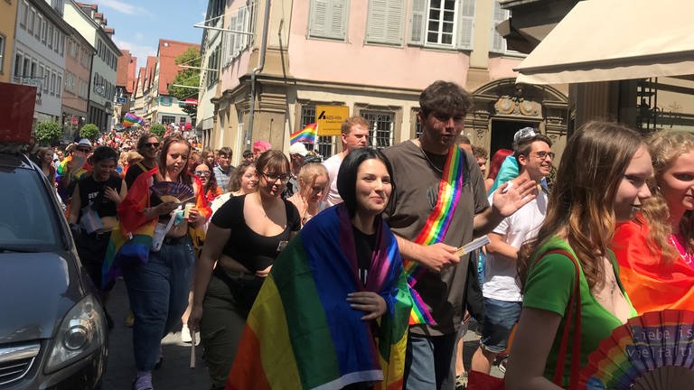 Queere und Unterstützer laufen beim Christopher Street Day bunt gekleidet durch die engen Gassen Schwäbisch Halls.