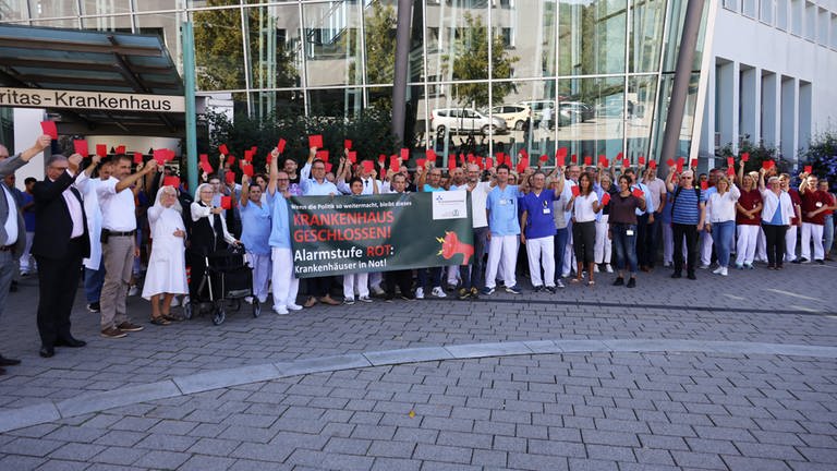 Rote Karte für die Politik: Die Mitarbeitenden des Caritas-Krankenhauses  demonstrierten heute in Bad Mergentheim und bei einer Kundgebung in Stuttgart für einen Inflationsausgleich und faire Finanzierungsbedingungen, um die wirtschaftliche Notlage der Krankenhäuser zu beenden. 