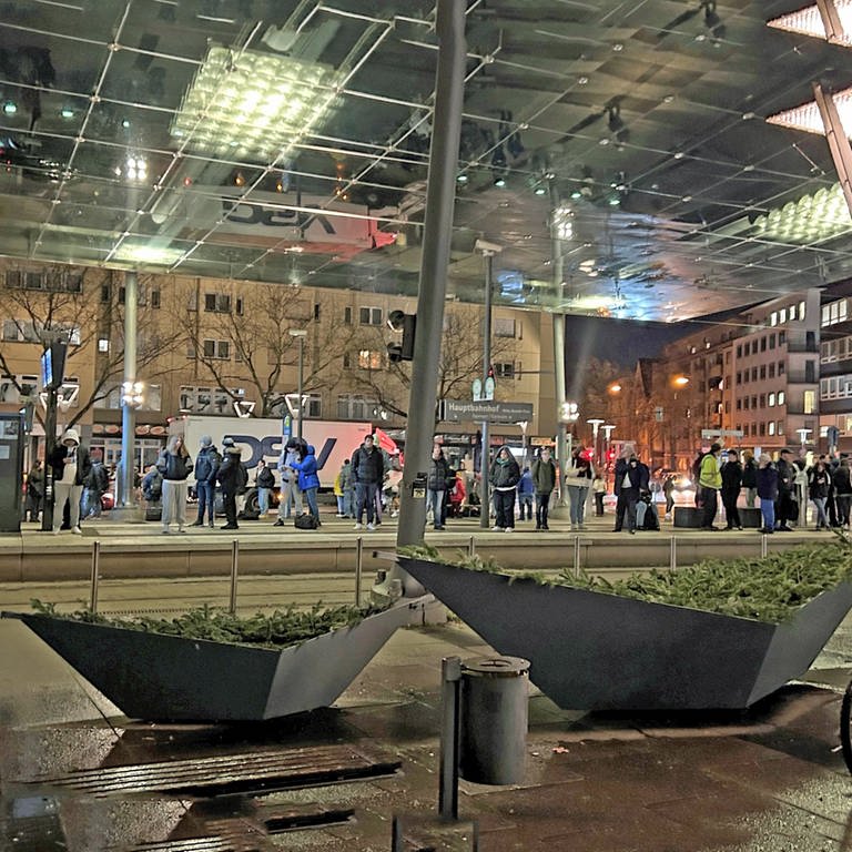 Wartende Pendlerinnen und Pendler auf dem Vorplatz des Heilbronner Hauptbahnhofs