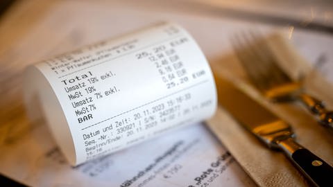 Eine Rechnung mit Umsatzsteuer und Mehrwertsteuer liegt auf der Speisekarte eines Restaurants. (Foto: picture-alliance / Reportdienste, picture alliance/dpa | Sina Schuldt)