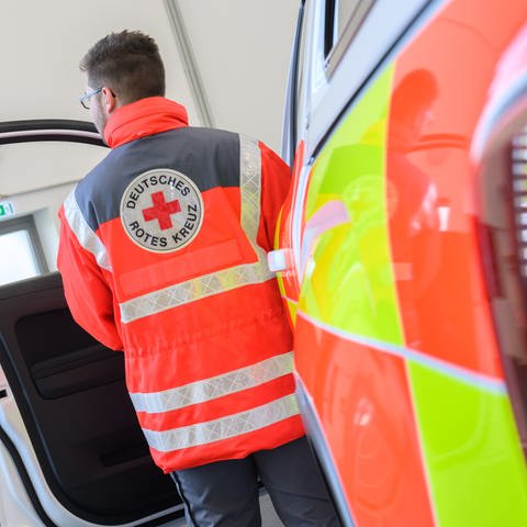 Ein Helfer vom Deutschen Roten Kreuz vor einem Rettungswagen