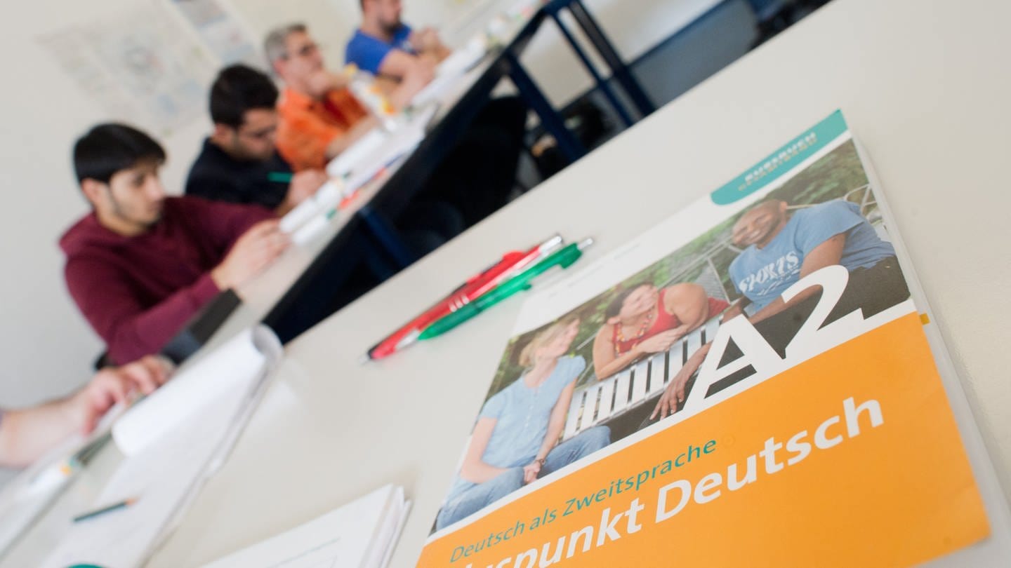 Ein Deutschbuch liegt in einem Integrationskurs (Foto: SWR, picture alliance/dpa | Julian Stratenschulte)