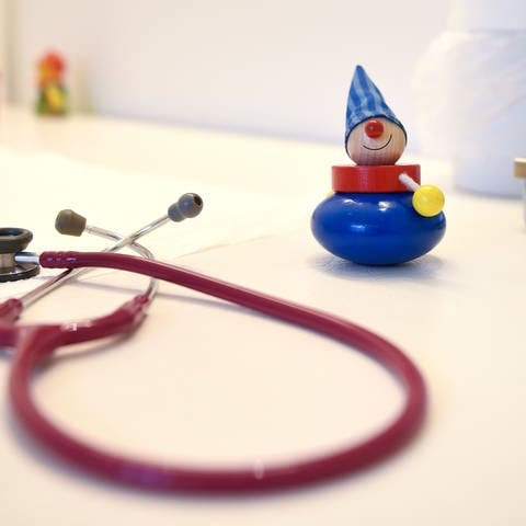 Ein Stethoskop und Kinderspielzeug liegen in einer Kinderarztpraxis