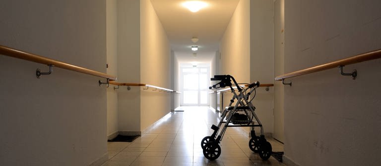 Ein Rollator steht in einem Flur eines Pflegeheims. Symbolbild für Corona-Ausbruch in Iffezheimer Pflegeheim (Foto: imago images, IMAGO / Zoonar)