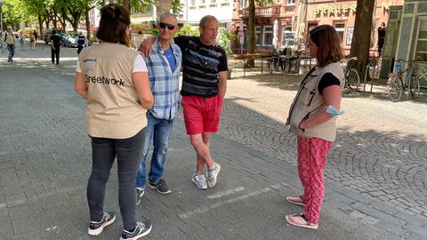 Streetworkerinnen der Diakonie sprechen auf dem Werderplatz in Karlsruhe mit zwei Männern (Foto: SWR, SWR, Cornelia Stenull)