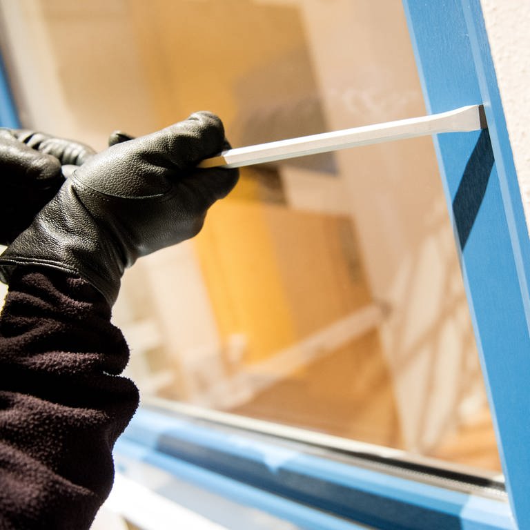Ein Mensch mit schwarzen Handschuhen versucht mit einem Schraubenzieher ein Fenster aufzuhebeln (Foto: dpa Bildfunk, Daniel Bockwoldt/picture-alliance/dpa)