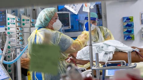 Pfleger versorgen in einem Krankenhaus eine Corona-Patienten auf der Intensivstation (Foto: dpa Bildfunk, picture alliance/dpa/Peter Kneffel)