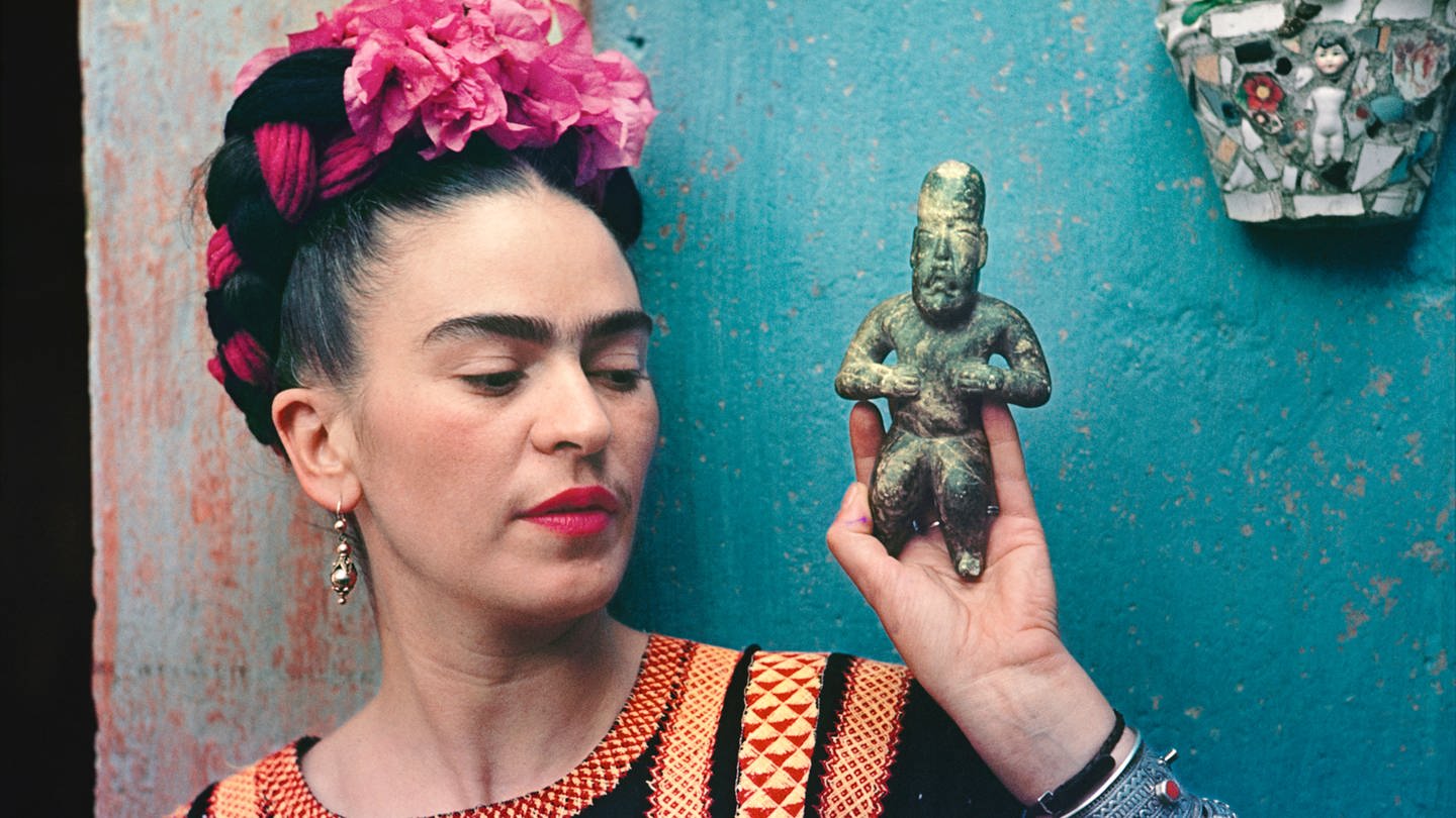 Die mexikanische Mahlerin Frida Kahlo mit einer Olmec Figur.